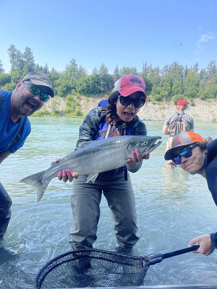 Gina Wall holding a salmon on an Alaska river