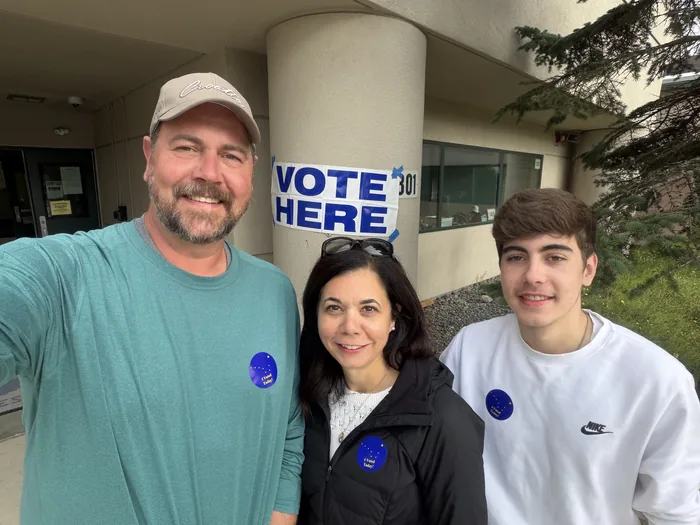 Gina Wall with her husband and son outside a Vote Here polling place